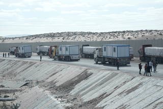 Truck drivers, transporting humanitarian aids, wait to enter Gaza